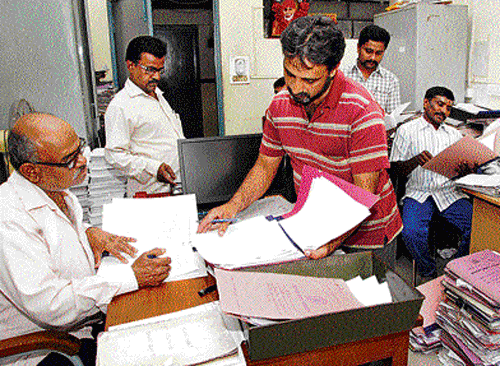 Clearing backlog: The Revenue department employees busy in disposing old files at the MS Building in Bangalore on  Sunday. dh photo