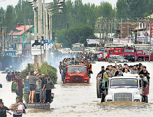 People are evacuated in trucks from the flood-hit Batamaloo area of Srinagar on Sunday / DH Photo