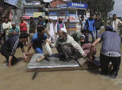 Flood waters Monday inundated most of Srinagar s residential and commercial areas as people scrambled to save whatever they could from the muddy, swirling waters. PTI file photo