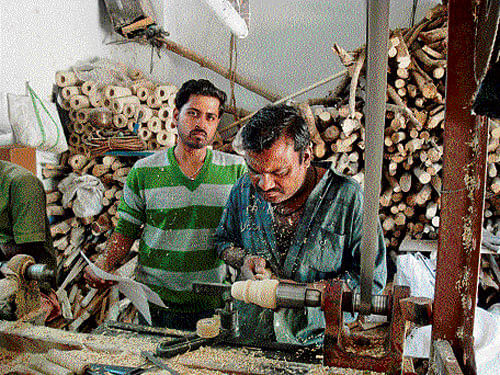 Skilled hands : Artisans at work at the Trust; (below) Lacquering of wood.