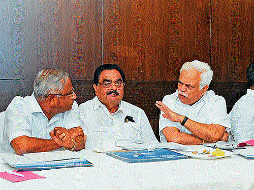 Minister for Higher Education and Tourism R V Deshpande discusses a point with MLA J R Lobo, at a meeting in Mangalore on Monday. District-in-Charge Minister Ramanath Rai looks on. DH Photo