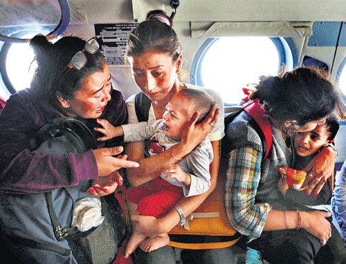 Helping hands : Tourists comfort their crying children inside an Air Force helicopter after being rescued from a flooded neighbourhood in Srinagar on Wednesday. PTI
