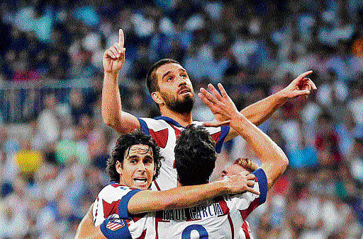Atletico's Arda Turan is mobbed by team-mates. Reuters Image