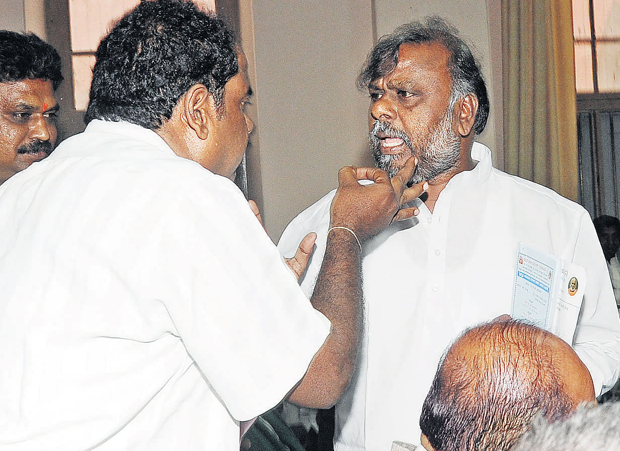 An angry protestor argues with Social Welfare minister H Anjaneya at a meeting on Upper Bhadra project in Bangalore on Sunday. DH photo