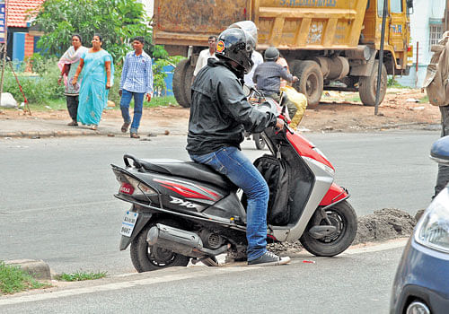 A&#8200;motorist crossing Hosur Road. DH Photos by SK Dinesh