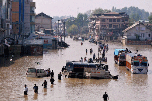 People wade through flood water at Jahangir Chowk in Srinagar on Monday. PTI Photo