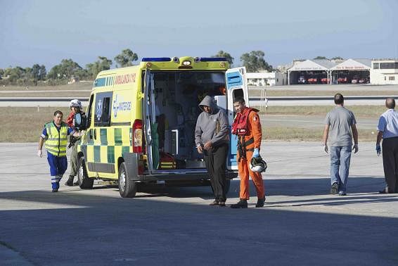 A migrant is helped by an Armed Forces of Malta (AFM) airman to a waiting ambulance after being brought to Malta by helicopter at the Air Wing base outside Valletta in this handout taken September 14. Reuters