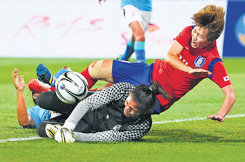 South Korea's Younga Yoo (right) is tackled by India's goalkeeper Aditi Chauhan during their women's football match of the 17th Asian Games in Incheon on Wednesday. AP Photo