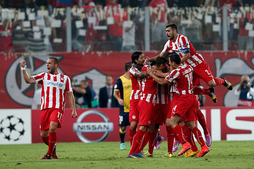 Olympiakos' players celebrate after scoring their third goal against Atletico Madrid on Tuesday. The Greek side beat last season's runners-up 3-2.
