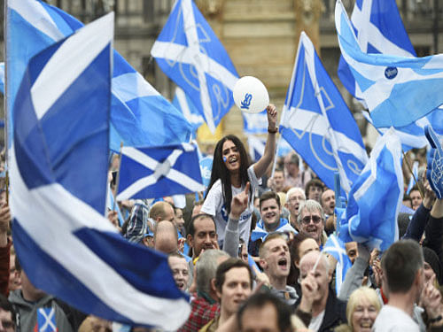 Campaigners wave Scottish Saltires at a 'Yes' campaign rally in Glasgow, Scotland. The Scottish independence referendum started Thursday as polling stations opened for voting on the question 'Should Scotland be an independent country?' Reuters photo