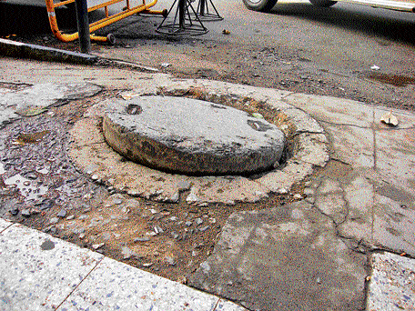 Stumbling block: A partially closed manhole on MG Road poses problems to pedestrians.