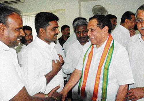 Minister Kimmane Ratnakar interacts with Congress workers at the KPCC Office in Bangalore on Friday. DH PHOTO