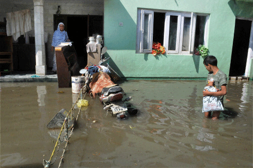 Days after he was airlifted along with his family to safety, ten-year-old Taukeer Ahmed was today on a rescue boat returning to his marooned house in Raj Bagh locality to retrieve his most loved possession -- his school bag. FIle photo - PTI