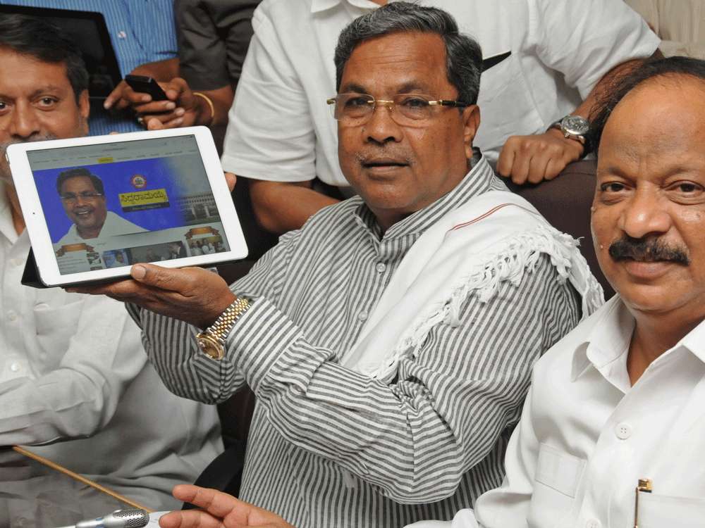 taking to new media: Chief Minister Siddaramaiah makes his social media debut in Bangalore on Monday. State representative in Delhi C S Nadagouda is with him. DH photo