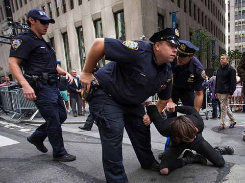Police detain a protester during the Flood Wall Street demonstration in Lower Manhattan, New York September 22, 2014. Hundreds of protesters marched through New York City s financial district on Monday and blocked streets near the stock exchange to denounce Wall Street 's role in raising money for businesses that contribute to climate change. REUTERS photo