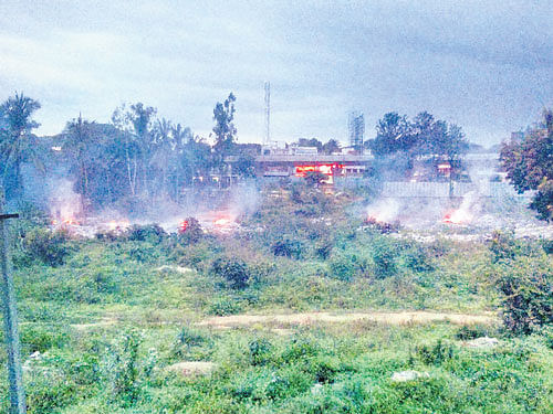Garbage burns on a vacant plot belonging to the APMC.