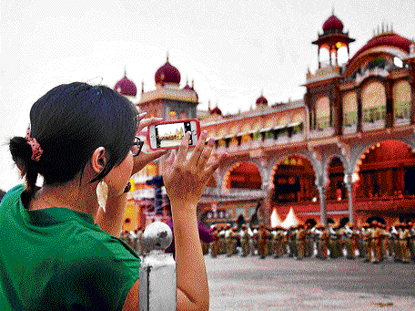 Memorable moment: A tourist captures the rehearsal of the police band on her mobile phone in front of the Mysore Palace on Wednesday.  DH PHOTO IRSHAD MAHAMMAD
