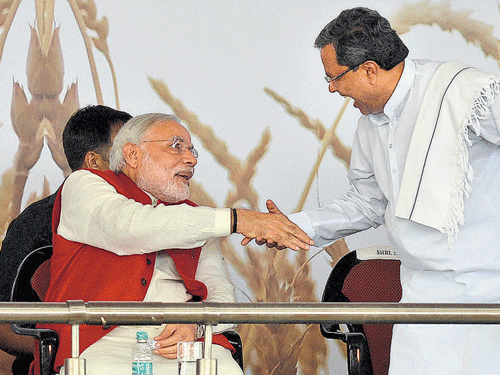 CAMARADERIE: Chief Minister Siddaramaiah greets Prime Minister Narendra Modi at the inauguration of the India food park in Tumkur on Wednesday. dh photo