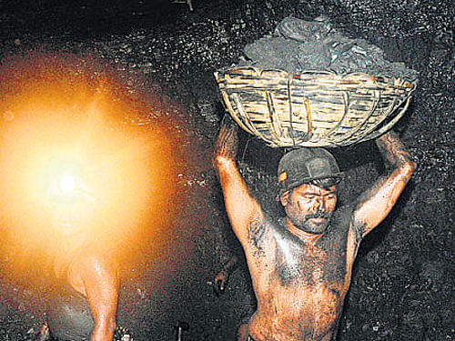 Miners carry baskets of coal inside a mine. File photo