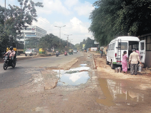 On the troubled path: Potholes are a common sight near Gopalan Arcade Mall at Rajarajeshwari Nagar on Mysore Road.