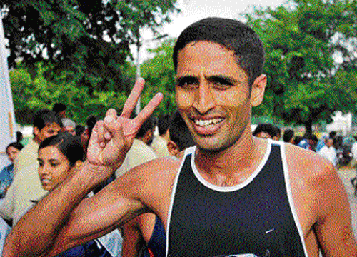 GLORY BC Thilak of Madikeri is all smiles after clinching the 21km half-marathon gold in the Dasara Games. DH PHOTO.