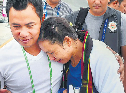 Boxer LaishramSarita Devi being consoled by her husband after the controversy in Incheon on Tuesday. PTI