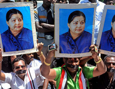 Supporters of AIADMK Supremo J Jayalalithaa hold her posters as they sit on a fast in protest against her conviction in a disproportionate assets case by a court, in Chennai. PTI photo