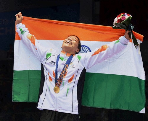 Boxer Mary Kom holds the Indian Tricolor as she celebrates after winning the gold medal in women's flyweight (48-51kg) categoryat the Asian Games in Incheon on Wednesday. PTI Photo