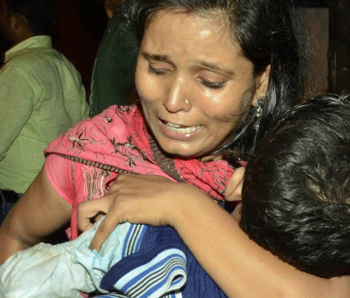 A woman carries a child killed in a stampede during Dasara festival celebrations in Patna on Friday. AP