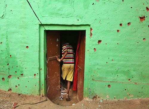 An Indian villager enters a door of his residence near mortar shell marks allegedly fired from the Pakistan's side at Masha da kothe village, in Arnia Sector near the India-Pakistan international border, about 47 kilometers (30 miles) from Jammu, India, Monday, Oct. 6, 2014. AP photo