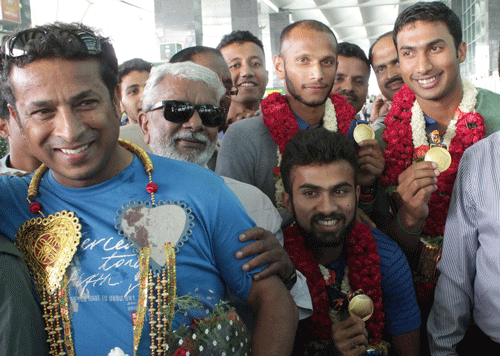 Asian Games gold medal winners of Indian Hockey team from left Assitant Coach Jude Felix, players Nikkin Thimmaiah, and S V Sunil,V R Raghunath with their medals during arrival at Kempegowda International Airport welcomed by Karnataka Hockey Association in Bangalore. DH photo