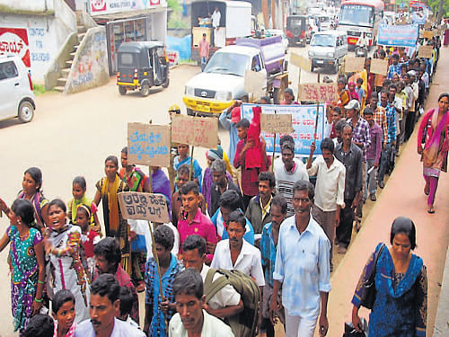 Demanding facilities for tribals and implementation of Forest Rights Act, members  of Karnataka Rajya Moola Aranya Adivasi Jenu Kurubara Sangha stage               a protest rally in Madikeri on Friday. (Right) The forest dwellers submit a petition to Deputy Commissioner Anurag Tewari. DH photos