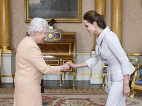 U.S actress Angelina Jolie, right, is presented with the Insignia of an Honorary Dame Grand Cross of the Most Distinguished Order of St Michael and St George by Britain's Queen Elizabeth II at Buckingham Palace, London. AP photo