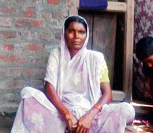 Babytai Rathod, whose husband committed suicide after the cotton crop failed in 2003, sits outside her home.