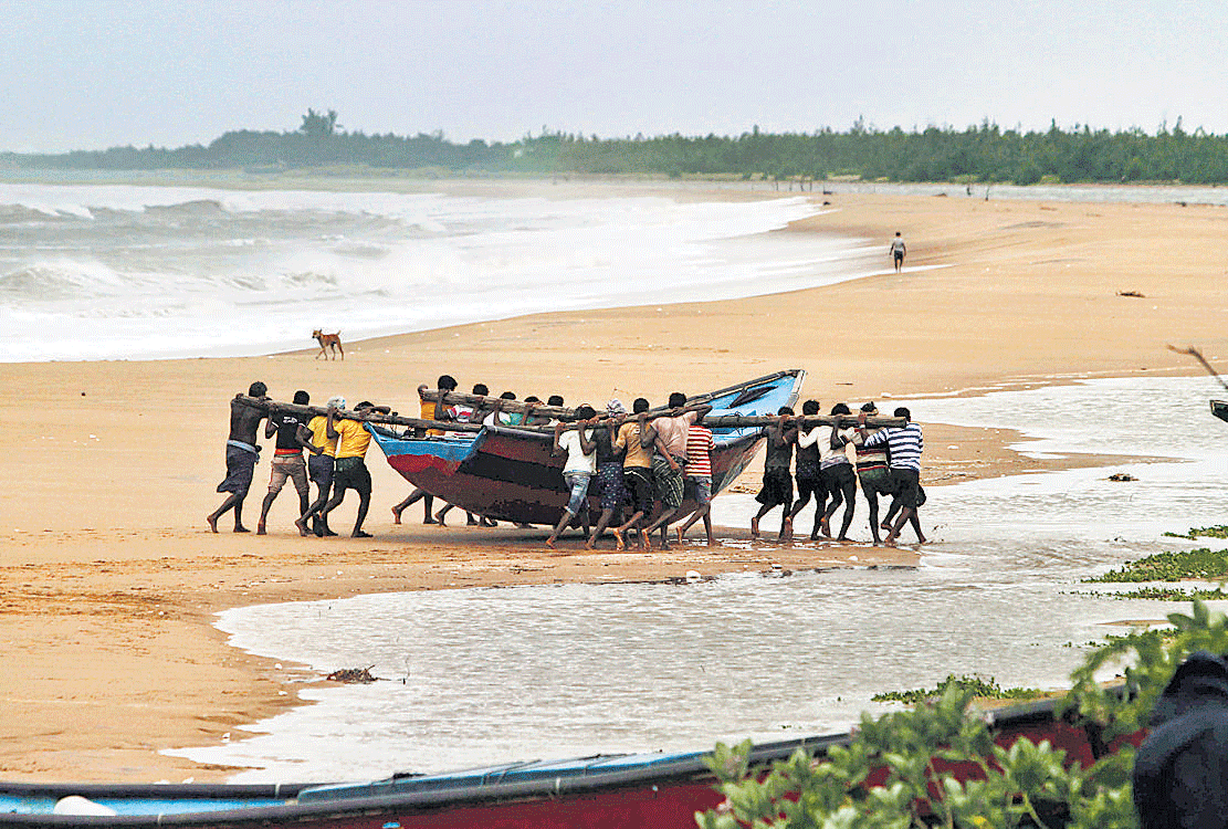 Fishermen move a boat away from the coast following a cyclone warning near  Podampeta village, on the outskirts of Gopalpur beach in Ganjam district. AP