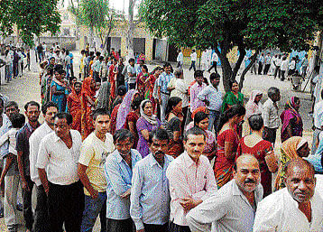People wait in long queues to cast votes in Assembly polls, at a polling station in Gurgaon on Wednesday. PTI