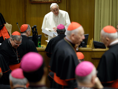 Pope Francis talks to prelates as he arrives at the morning session of a two-week synod on family issues at the Vatican, Saturday, Oct. 18, 2014. AP Photo