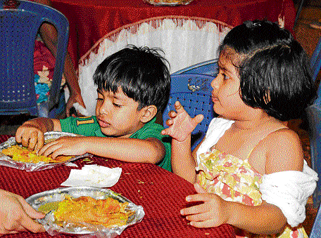 Delicious: Little foodies enjoying a bite. dh photos by SK Dinesh