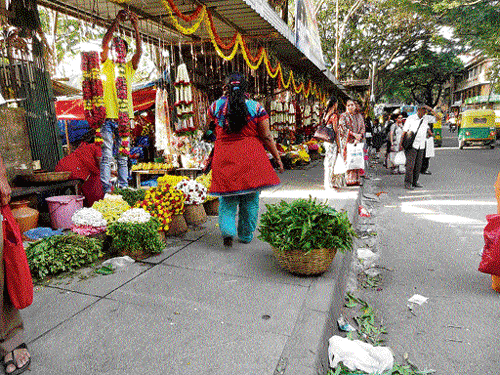 Encroaching: The flower vendors on the pavement.  DH Photos by BK Janardhan