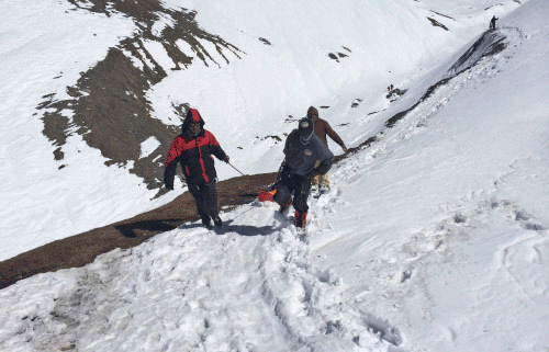 In this Friday, Oct. 17, 2014, handout photo provided by the Nepalese army, rescue team members carry the body of an avalanche victim at Thorong La pass area in Nepal. Rescuers widened their search Friday for trekkers stranded since a series of blizzards and avalanches battered the Himalayas in northern Nepal early this week, leaving at least 29 foreigners and locals dead, officials said. AP