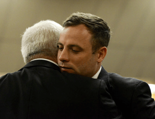 South African Olympic and Paralympic track star Oscar Pistorius hugs his father Henke Pistorius at the North Gauteng High Court in Pretori, where he was sentenced to 5 years in jail for killing his girlfriend Reeva Steenkamp. Reuters