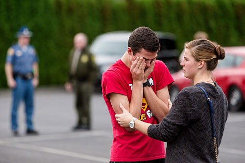 Marysville Pilchuck High School junior Carsyn Yorkoski, center, tearfully reunites with his sister, Kyla Yorkoski, right, at a reunification center near the scene of a school shooting that left two dead and four wounded Friday, Oct. 24, 2014, at Marysville Pilchuck High School in Marysville, Wash.  AP