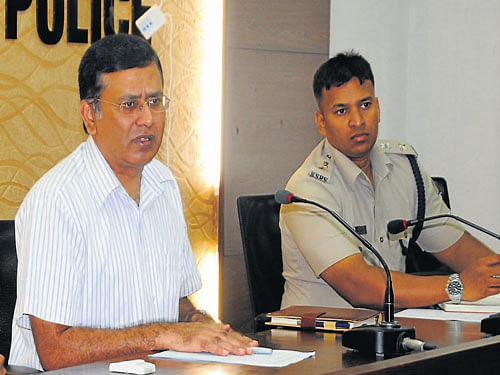 Police Commissioner R Hitendra speaks at monthly SC/ST meeting in Mangalore on Sunday. DCP Vishnuvardhan looks on. DH Photo