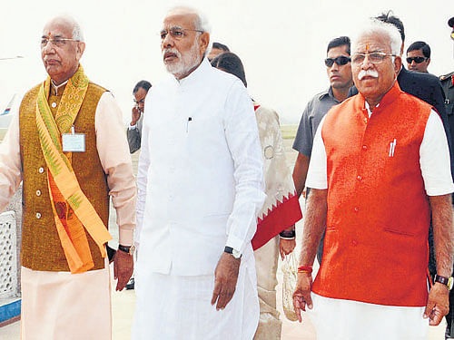 Prime Minister Narendra Modi is flanked by Haryana Governor Kaptan Singh Solanki (left) and new Haryana Chief Minister Manohar Lal Khattar at Chandigarh Airport  on Sunday. PTI