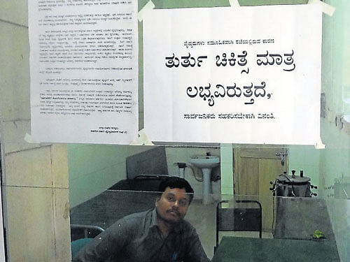 A placard stating 'emergency services only' was put up at a government hospital in Gundlupet, Chamarajanagar district, following en masse resignation of doctors across the State, on Monday. DH photo