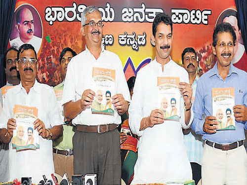 Dakshina Kannada District BJP President Pratap Simha Nayak releases 'Nooru Hejje', a book on achievements of MP Nalin Kumar Kateel and the NDA&#8200;Government during 100 days in power, at the district BJP office in Mangalore on Thursday. Nalin Kumar Kateel, former MLC Monappa Bhandary and others look on. DH photo