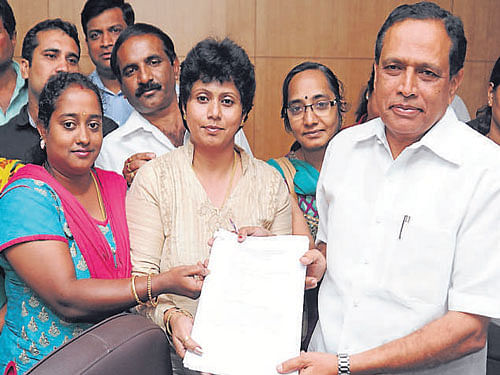 Minister Kimmane Ratnakar receives petitions from Orchids school parents at the Vidhana Soudha on Thursday. DH photo