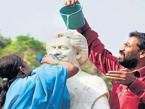 Congress party workers clean the statue of  former prime minister Indira Gandhi in Allahabad on Thursday. PTI