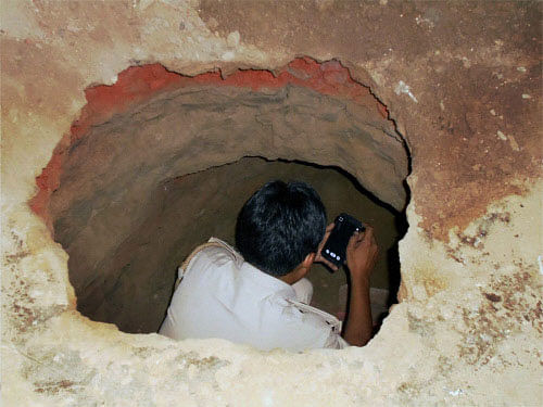 A police man investigates the tunnel dug up by the robbers in Gohana bank heist, in Sonipat. The Haryana Police on Thursday claimed a major breakthrough with the arrest of two people in the multi-crore heist at the Punjab National Bank, Gohana, in Sonipat district on Saturday night. PTI photo