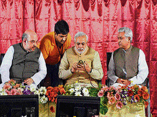 Prime Minister Narendra Modi dials Membership Number as BJP President Amit Shah and Ram Lal  look on. PTI